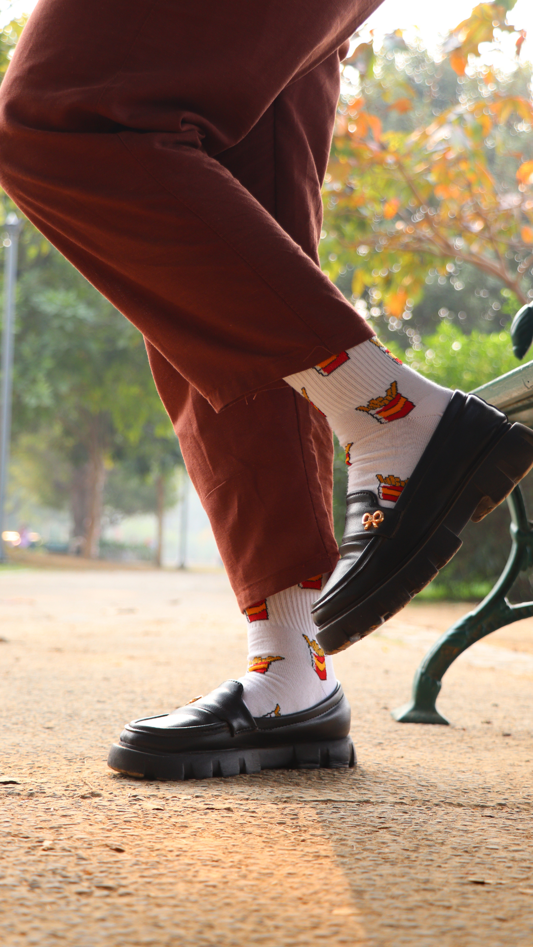 Model wearing Crispy Fries funky socks – white ankel-length cotton socks with a fun fries print, perfect for food lovers with a playful style.
