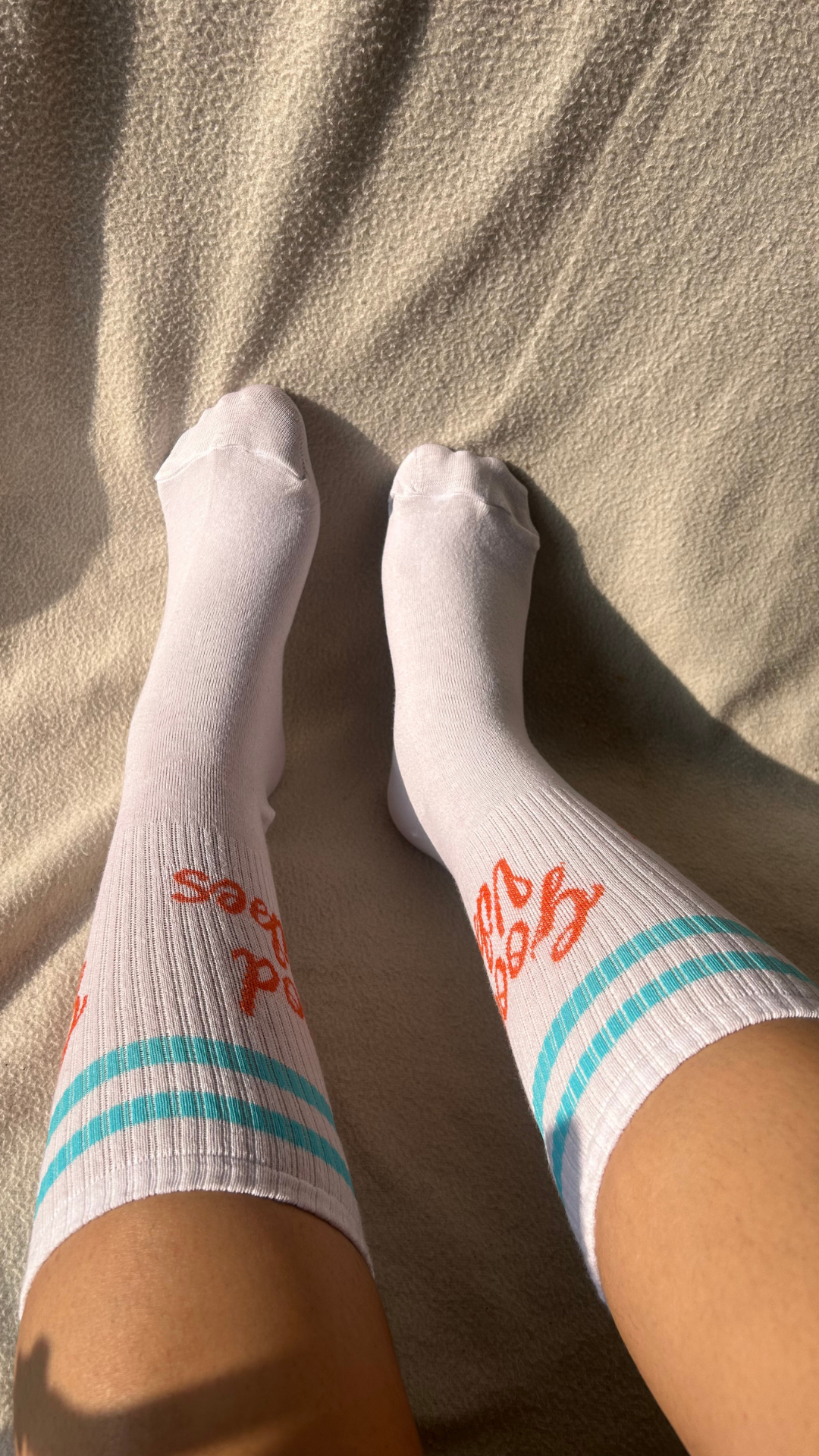 Model wearing Good Vibes funky socks – white crew-length socks featuring a positive and uplifting design, perfect for spreading good vibes wherever you go.