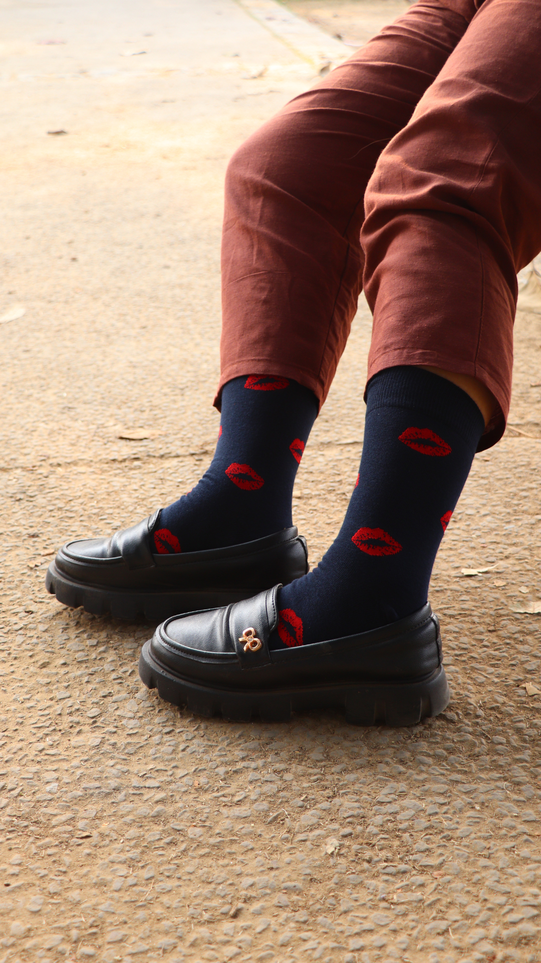 Model wearing Kiss Me funky socks – black crew-length cotton socks featuring a playful red lips print, perfect for making a bold, romantic statement.