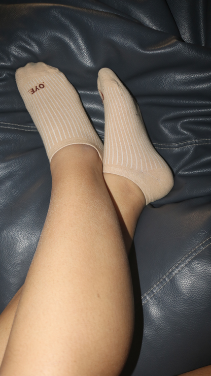 Model wearing Caramel Track funky socks – beige sneaker-length socks with a stylish caramel-colored track design, offering comfort and a trendy look for any occasion.