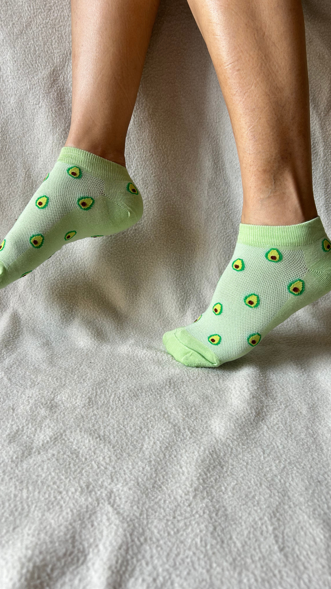 Model wearing Fresh Avocado funky socks – green crew-length socks featuring a playful avocado design, combining style and comfort for a fun, trendy look.