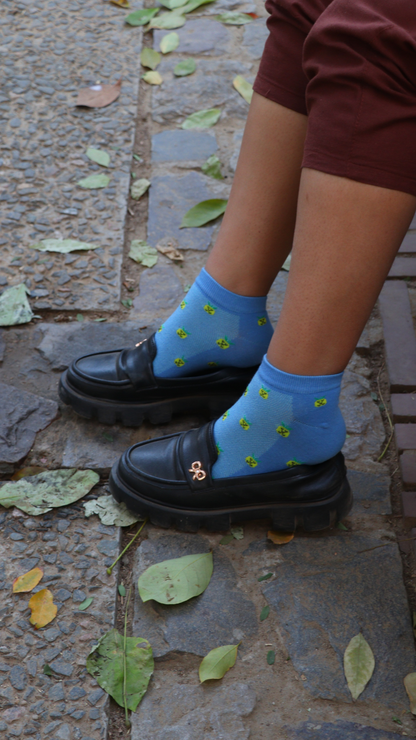 Model wearing Juicy Pineapple funky socks – blue sneaker-length cotton socks with a vibrant pineapple print, offering a tropical and fresh look for a fun, fruity vibe.







