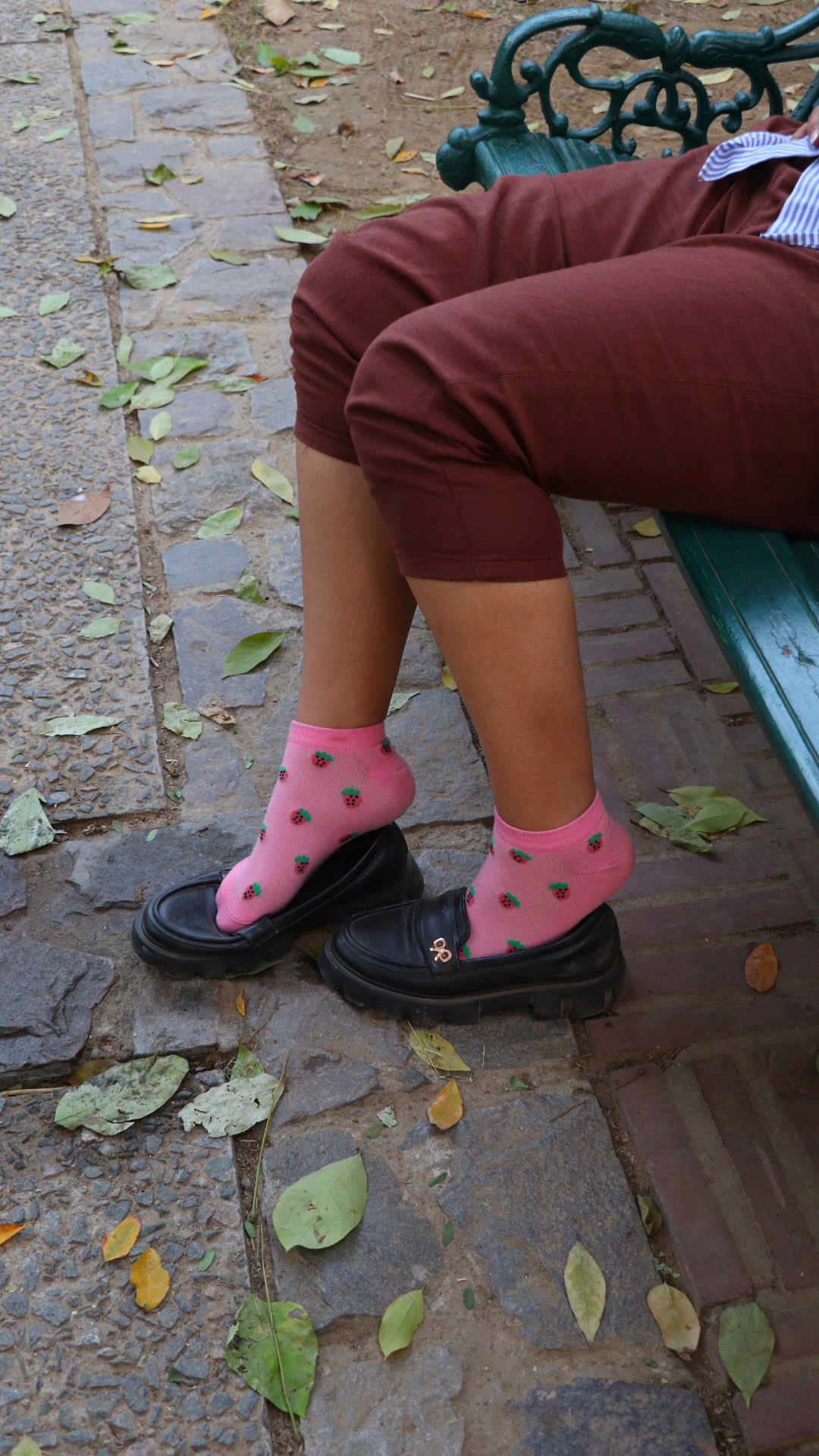 Model wearing Juicy Strawberries funky socks – pink sneaker-length cotton socks with vibrant strawberry print for a fresh, fruity look.