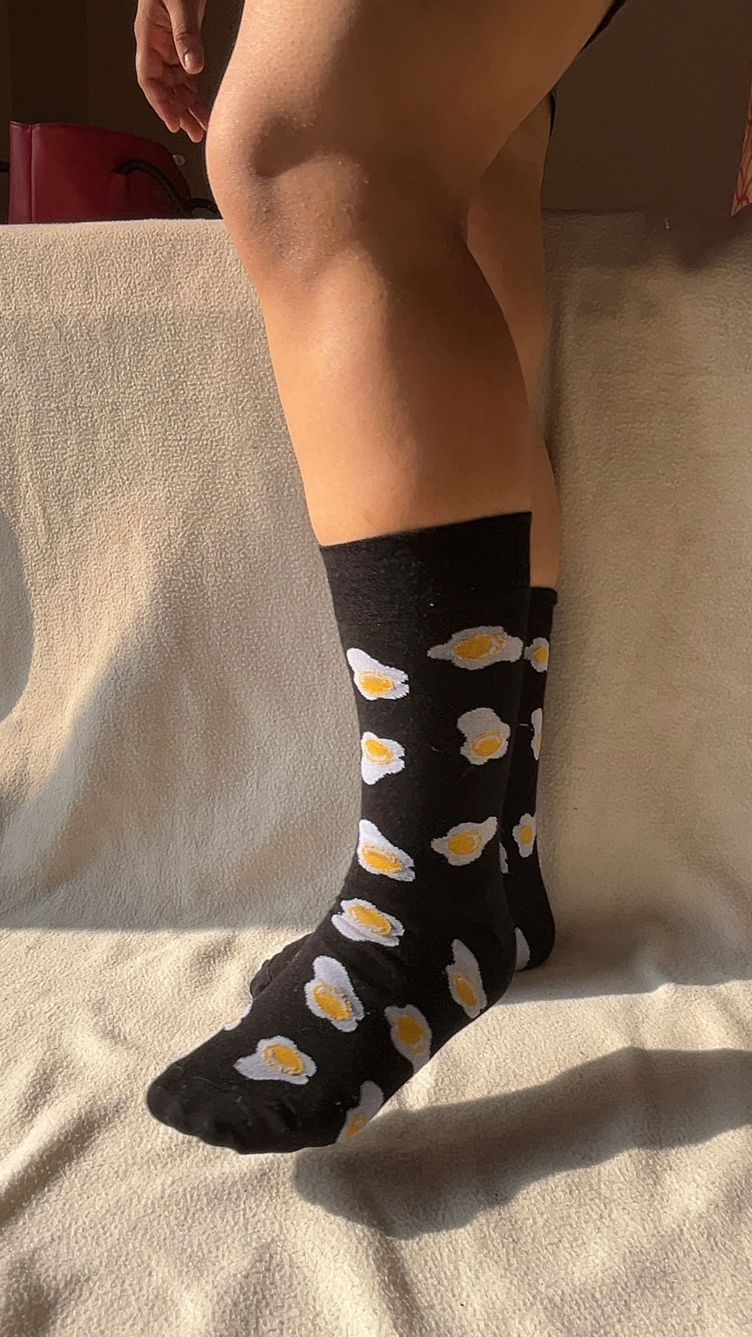 Model wearing Sunny Side Up funky socks – white crew-length cotton socks with a playful sunny side up egg print, bringing a cheerful and quirky vibe to your look.