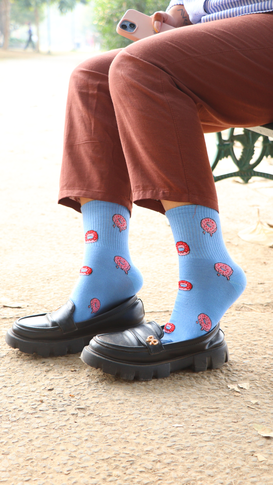 Model wearing Sweet Donut funky socks – blue ankel-length cotton socks featuring a playful donut print, perfect for adding a fun and sweet touch to your look.