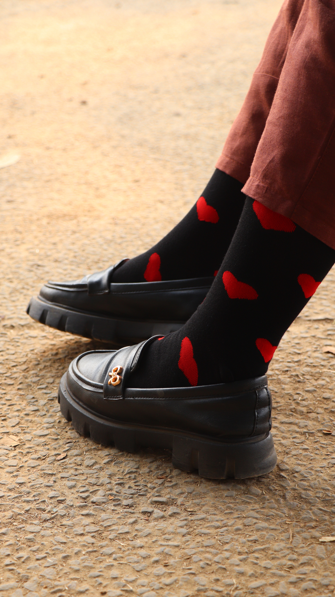 Model wearing Take My Heart Black funky socks – black crew-length cotton socks with a bold heart print, perfect for expressing love and adding a playful touch to any outfit.